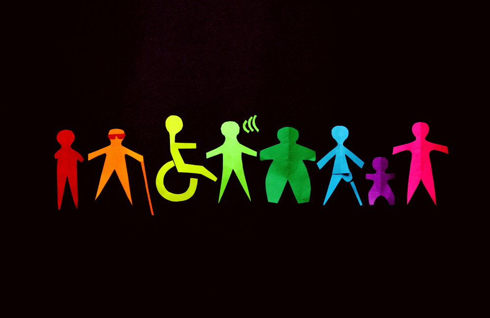 mensen met verschillende handicaps, waaronder een persoon met wandelstok, een rolstoelgebruiker en een persoon met een gehoorhandicap, hand in hand.